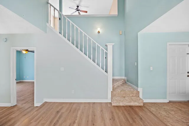 a view of hallway with stairs and wooden floor
