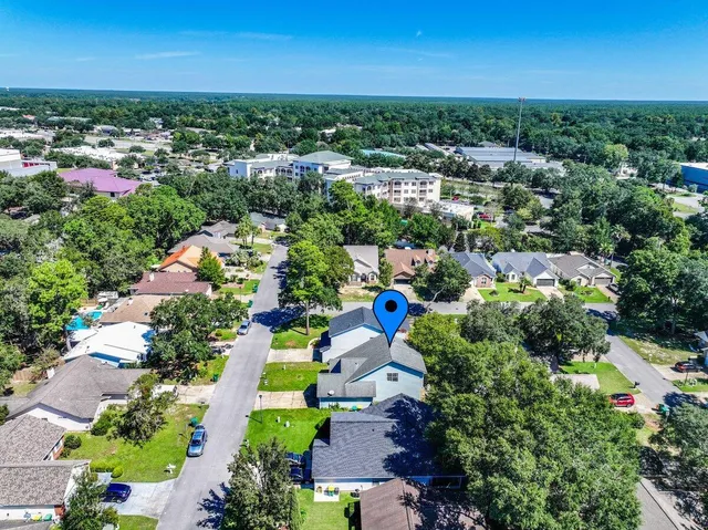 an aerial view of residential houses with outdoor space and trees