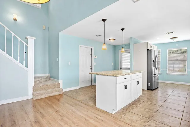 a kitchen with granite countertop a stove a sink and a refrigerator