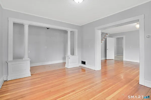 a view of empty room with wooden floor
