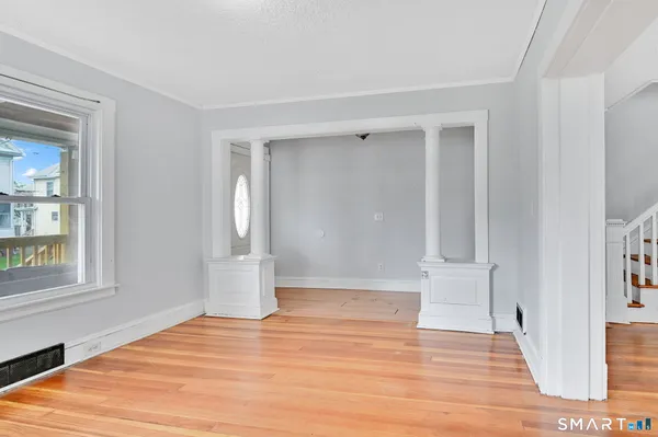 a view of empty room with wooden floor and fan