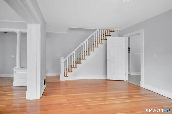 a view of entryway and hall with wooden floor