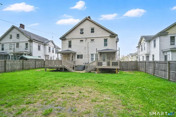 a view of a house with a yard and deck