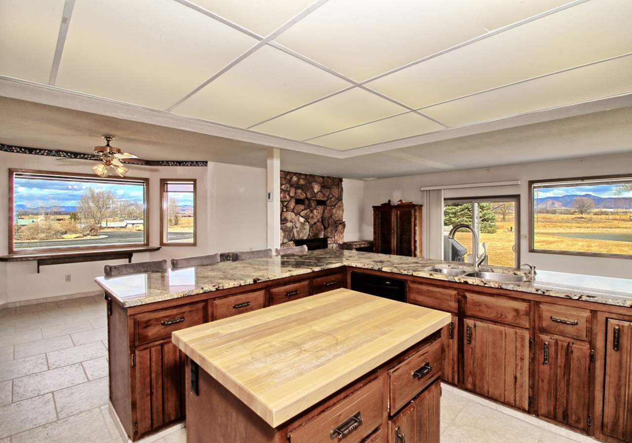 1420 18 Road Fruita, CO 81521 - Photo 17 of 42 a living room with granite countertop furniture a flat screen tv and a large window