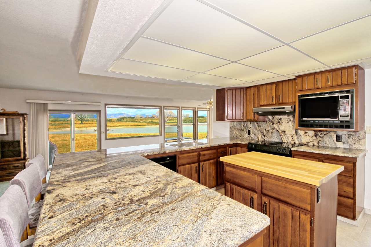 1420 18 Road Fruita, CO 81521 - Photo 18 of 42 a large kitchen with stainless steel appliances a stove a sink and a microwave