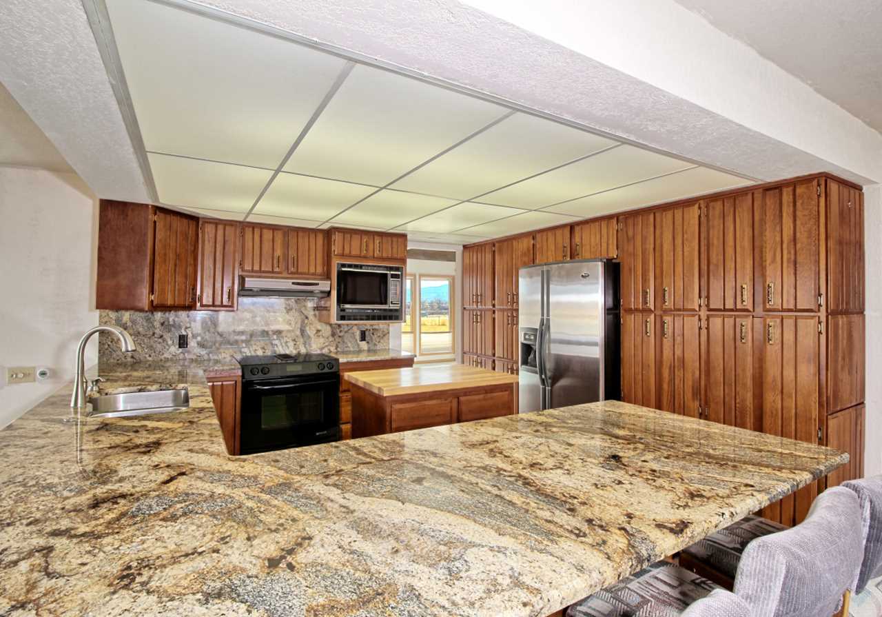 1420 18 Road Fruita, CO 81521 - Photo 19 of 42 a large kitchen with kitchen island a stove a sink dishwasher and wooden cabinets