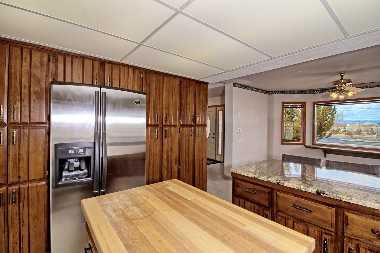 1420 18 Road Fruita, CO 81521 - Photo 20 of 42 a kitchen with granite countertop a refrigerator and a sink