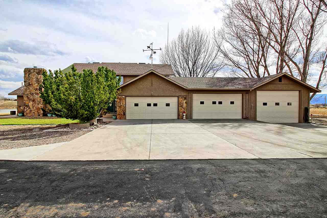 1420 18 Road Fruita, CO 81521 - Photo 2 of 42 a front view of a house with a yard and garage