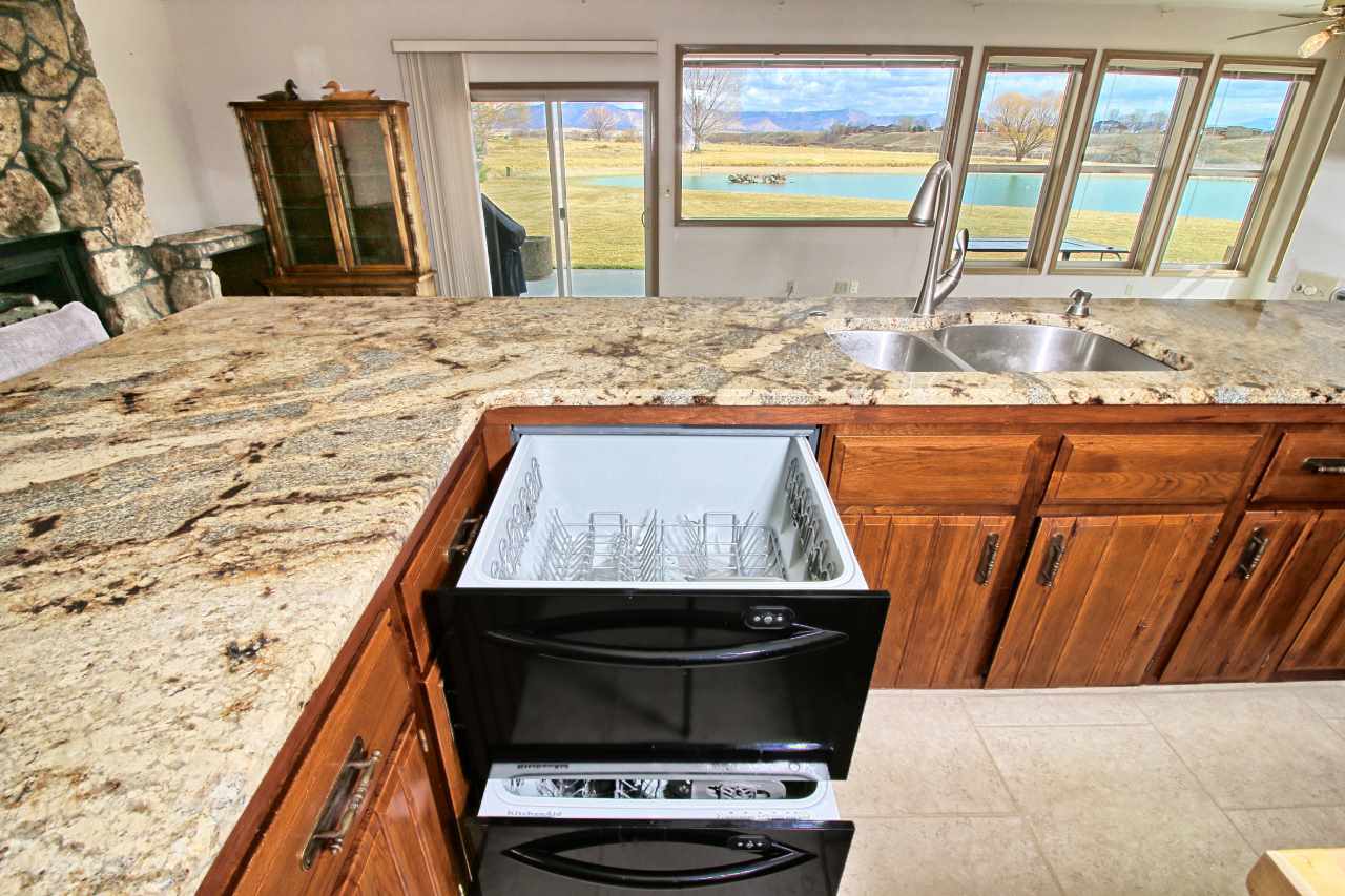 1420 18 Road Fruita, CO 81521 - Photo 21 of 42 a living room with stainless steel appliances kitchen island granite countertop wooden floor and a window