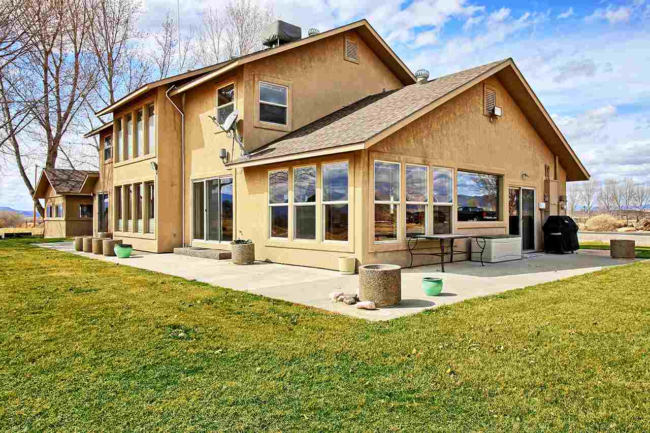 1420 18 Road Fruita, CO 81521 - Photo 5 of 42 a front view of a house with a yard table and chairs