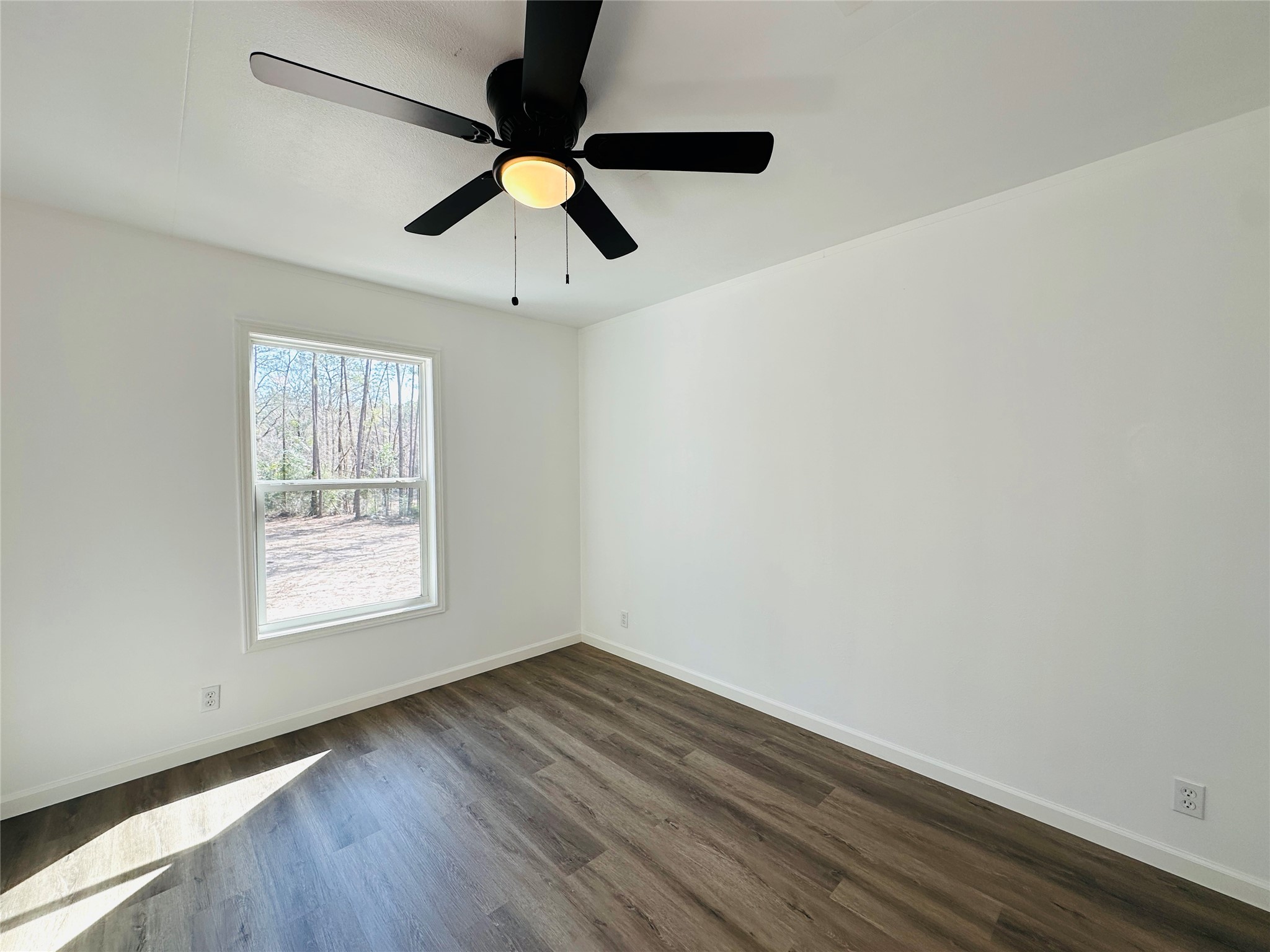 11269 Newton Circle Conroe, TX 77303 - Photo 25 of 39 an empty room with wooden floor fan and windows