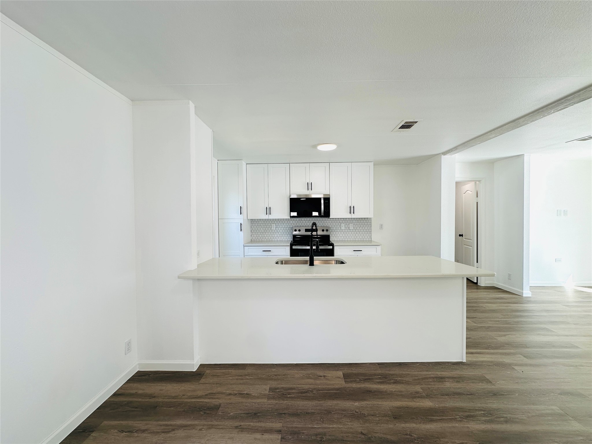 11269 Newton Circle Conroe, TX 77303 - Photo 6 of 39 a view white kitchen with wooden floor and stainless steel appliances
