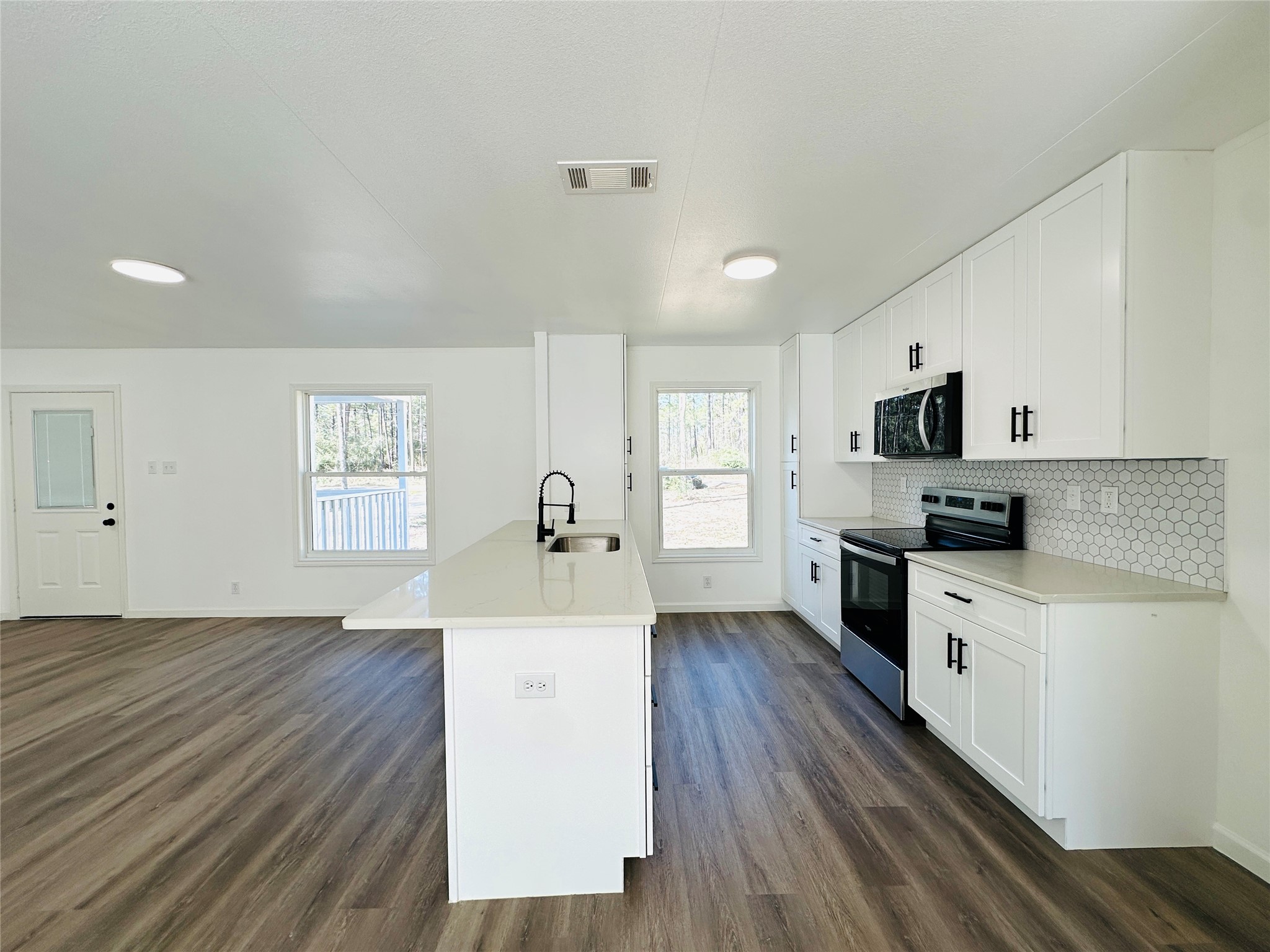11269 Newton Circle Conroe, TX 77303 - Photo 7 of 39 a kitchen with granite countertop a stove top oven a sink dishwasher and a refrigerator with wooden floor
