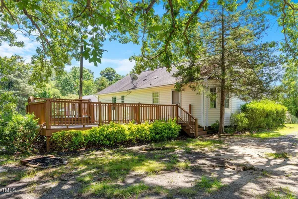 a view of a garden with potted plants and large trees