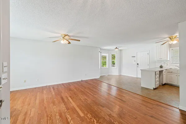 a view of a kitchen with wooden floor and a window