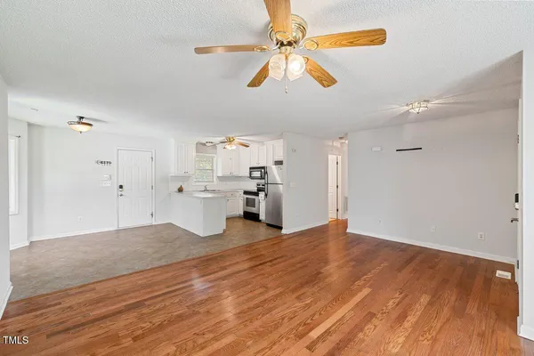 a view of a kitchen with wooden floor and a ceiling fan