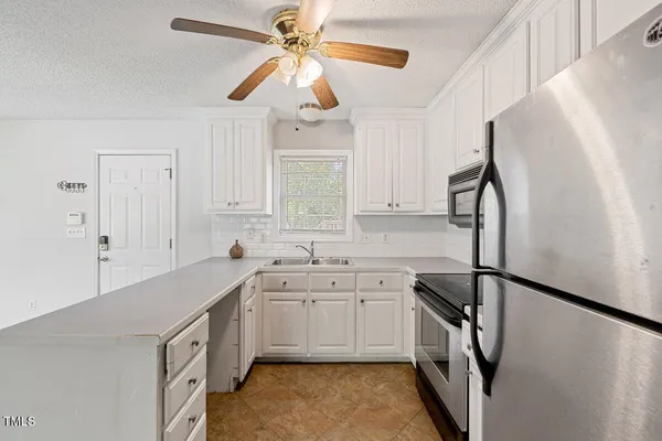 a kitchen with a sink appliances and cabinets