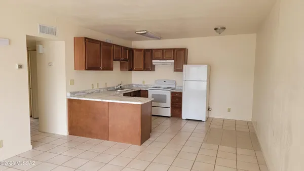 a kitchen with a refrigerator and a stove top oven