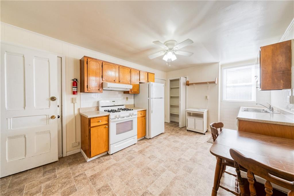 1509 Hatteras Street Pittsburgh, PA 15212 - Photo 6 of 28 a large white kitchen with a stove a sink dishwasher and a refrigerator with wooden floor