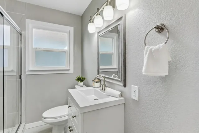 a bathroom with a sink a toilet and a mirror