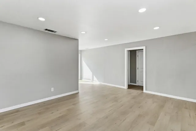 a view of an empty room with wooden floor