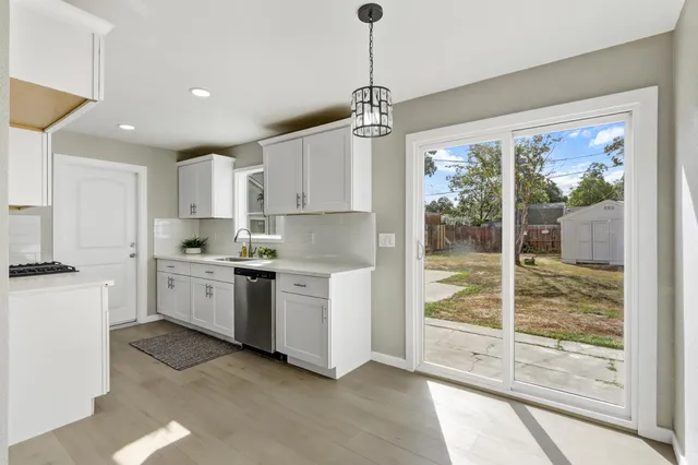 a kitchen with white cabinets and window