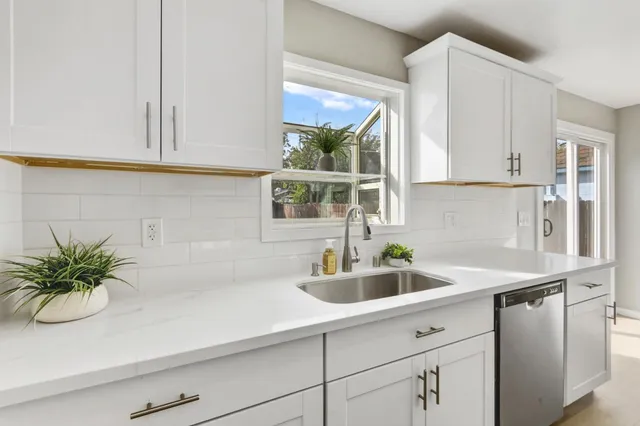 a kitchen with a sink a window and cabinets