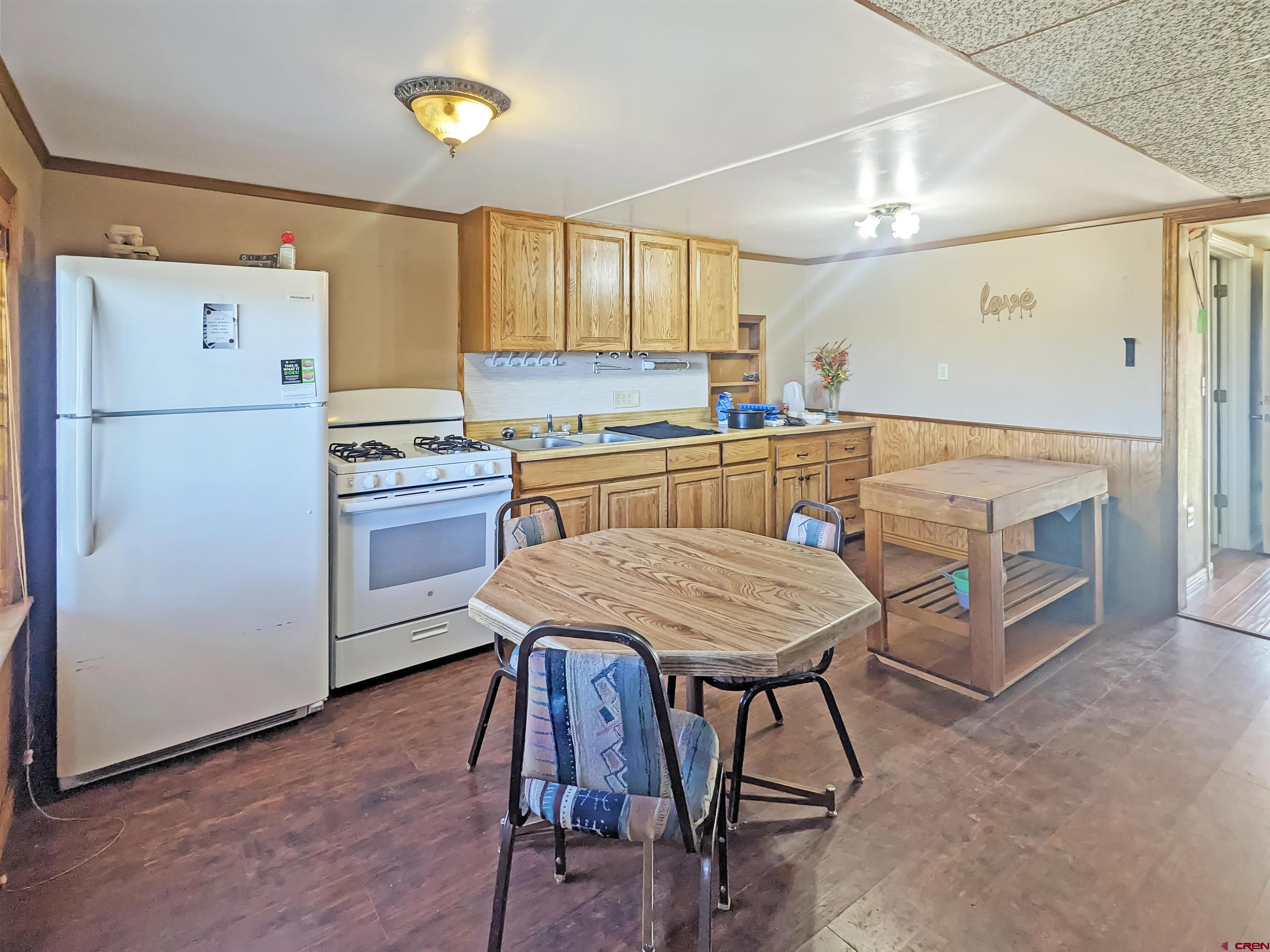 30822 Mailbox Park Road Redvale, CO 81431 - Photo 3 of 32 a kitchen with a table chairs refrigerator and cabinets