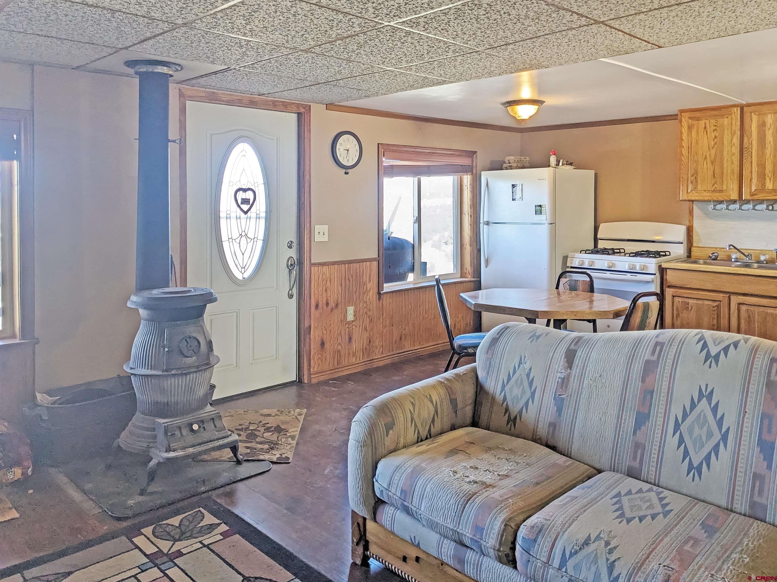30822 Mailbox Park Road Redvale, CO 81431 - Photo 5 of 32 a living room with furniture a clock on wall and a window