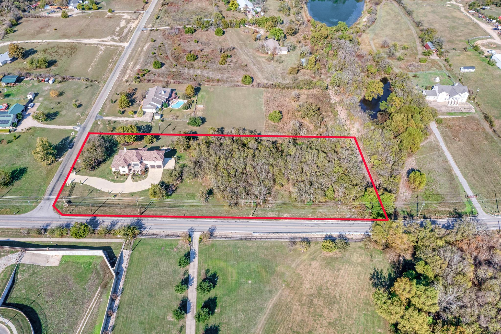 104 Spring Valley Street Hutto, TX 78634 - Photo 35 of 40 Aerial view of property and surrounding area with property parcel outlined and a nearby body of water