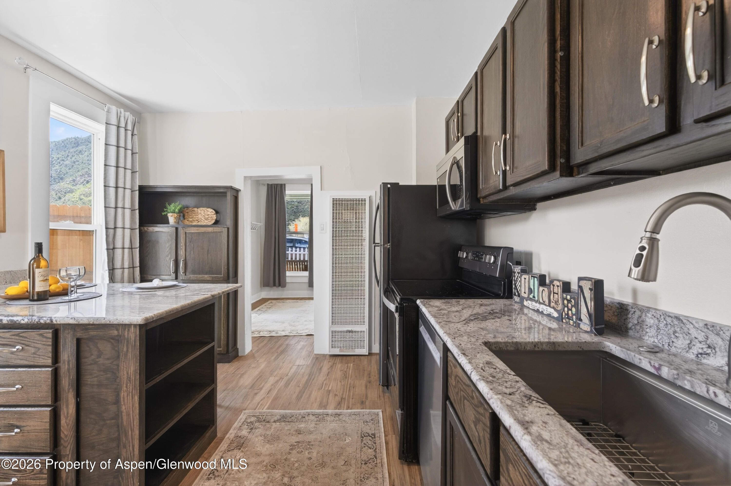 620 West Main Street New Castle, CO 81647 - Photo 14 of 27 a kitchen with granite countertop a sink a counter top space stainless steel appliances and cabinets