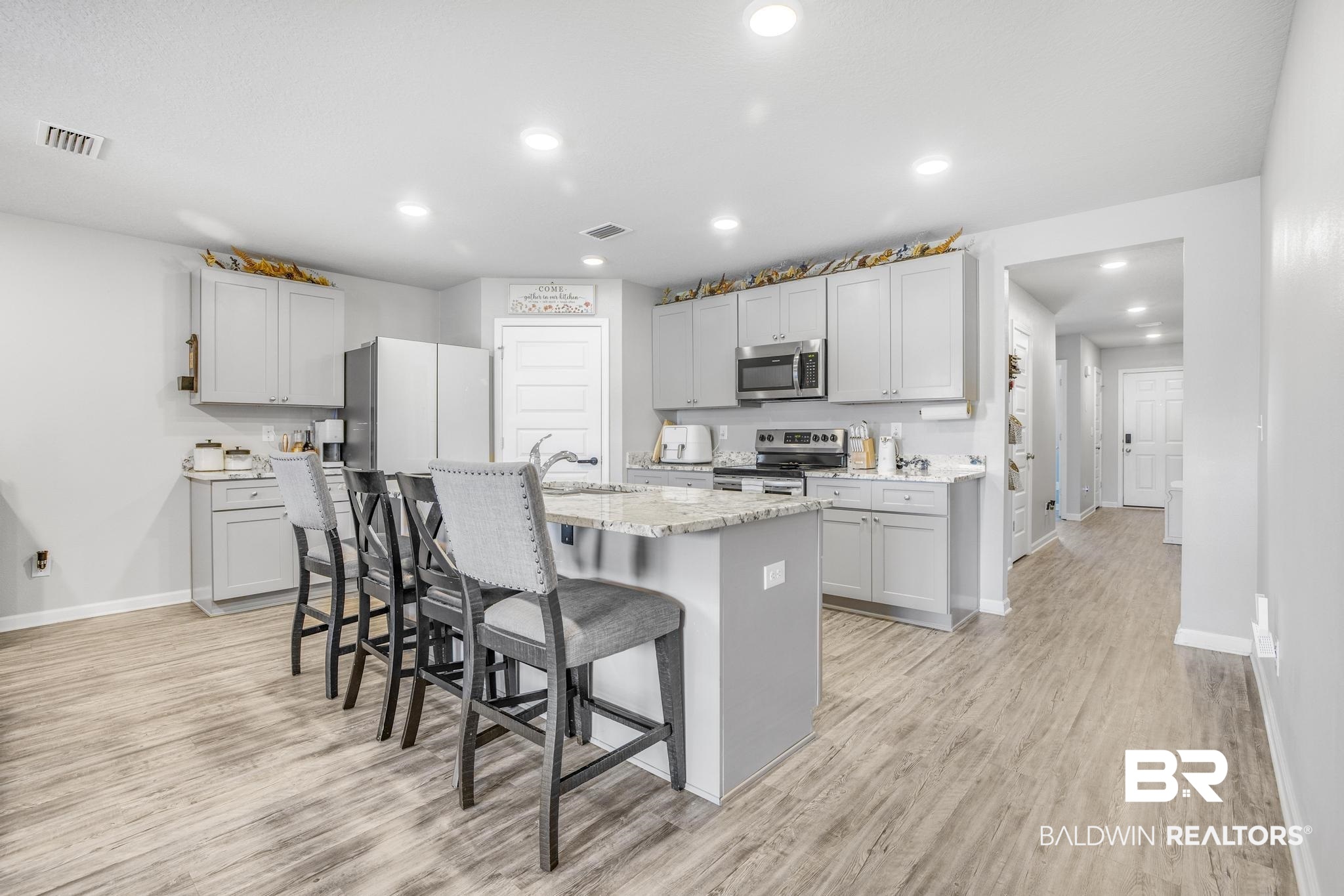 10738 Ridgeview Drive Mobile, AL 36608 - Photo 8 of 48 Kitchen with a kitchen breakfast bar, recessed lighting, light wood-type flooring, a center island with sink, and gray cabinetry