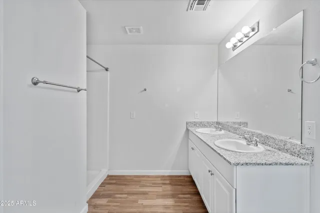 a spacious bathroom with a granite countertop sink and a mirror