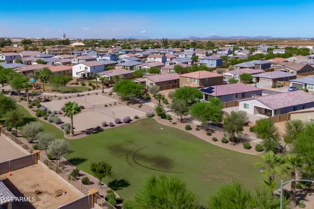 an aerial view of residential houses with outdoor space and trees