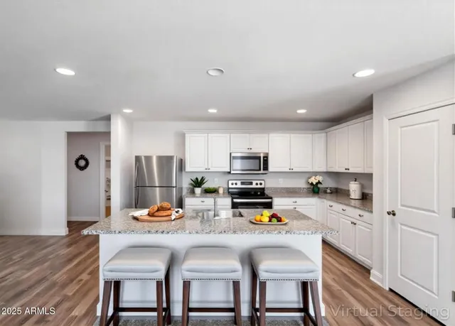 a kitchen with white cabinets and refrigerator