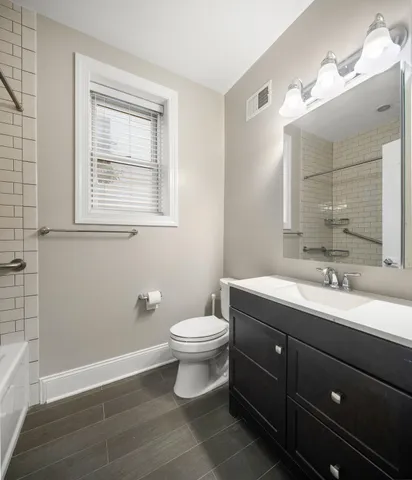 a bathroom with a toilet sink and mirror