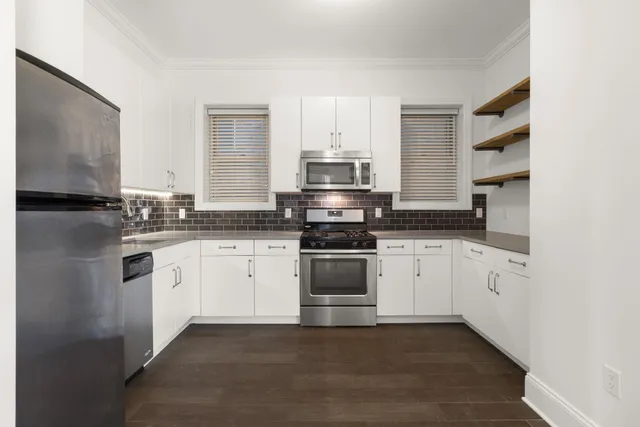 a kitchen with granite countertop white cabinets and stainless steel appliances