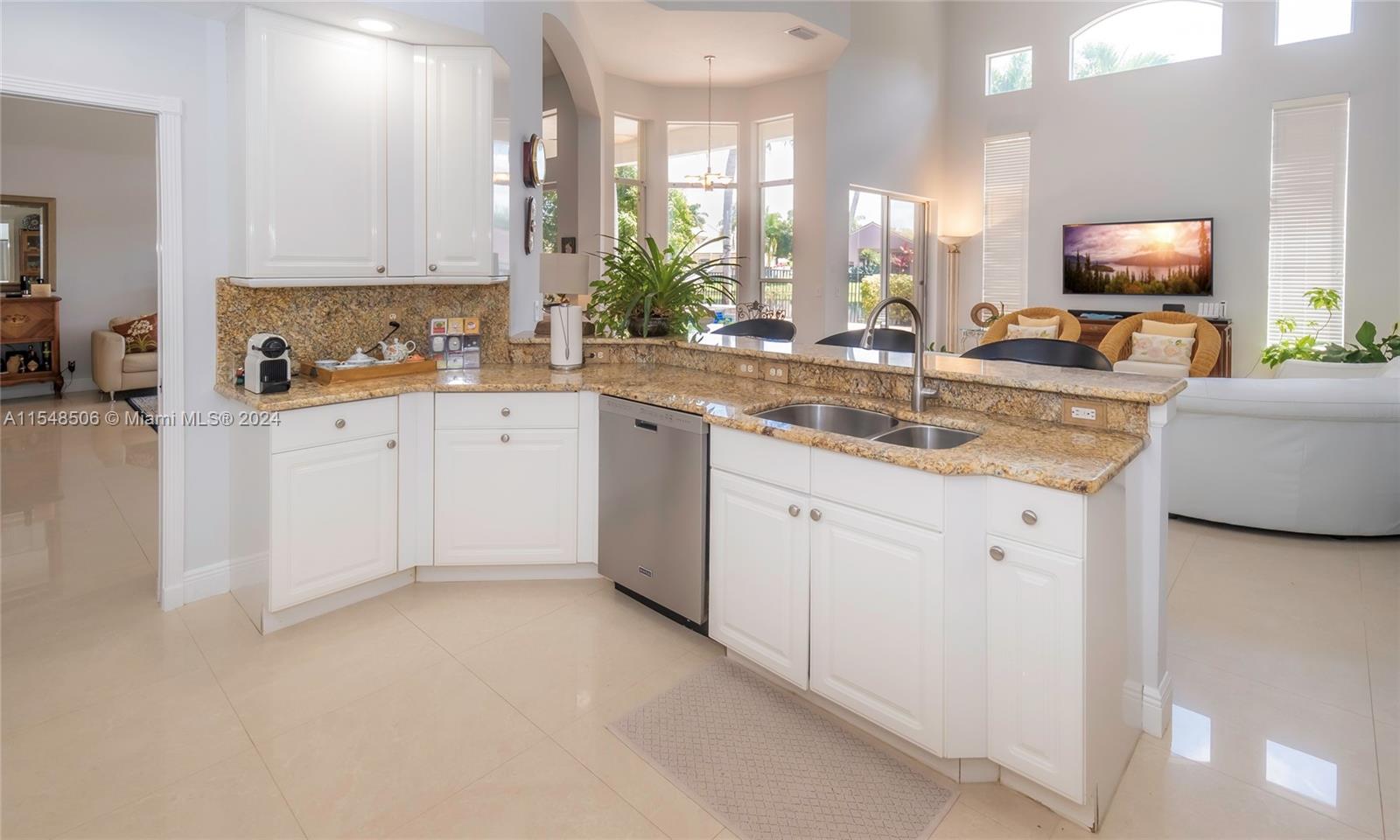 10849-10849 Bal Harbor Drive Boca Raton, FL 33498 - Photo 24 of 72 a kitchen with granite countertop white cabinets white appliances a sink and a window