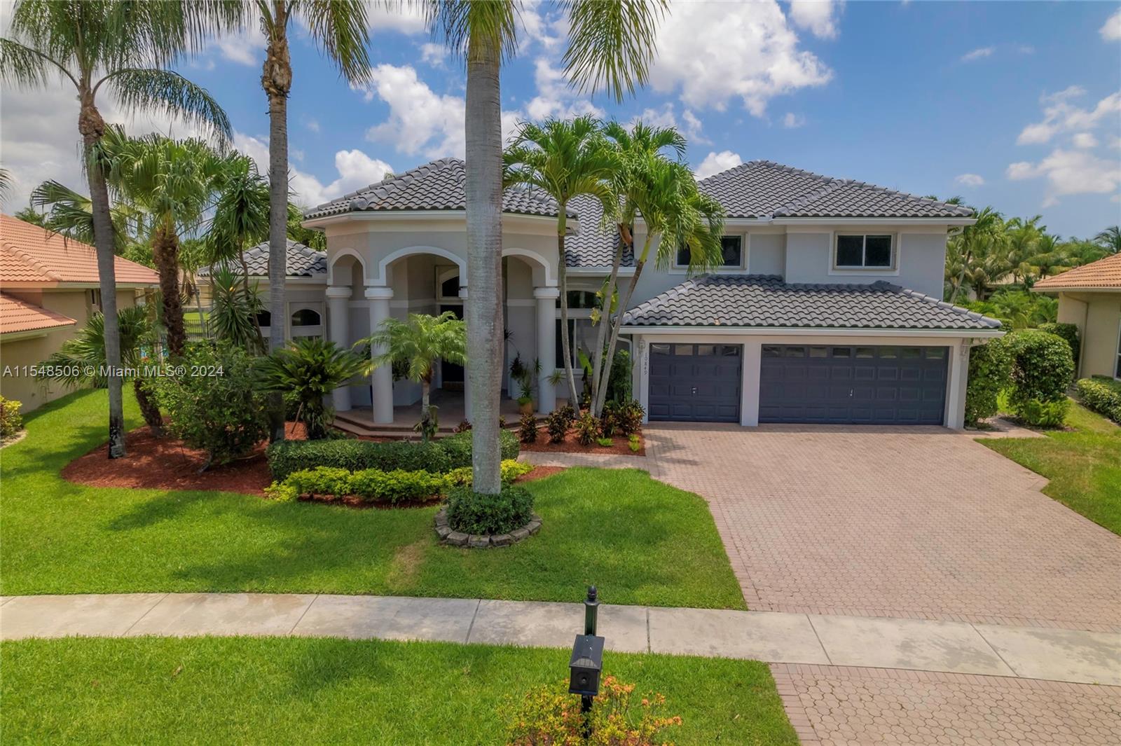 10849-10849 Bal Harbor Drive Boca Raton, FL 33498 - Photo 3 of 72 a front view of a house with a garden and plants