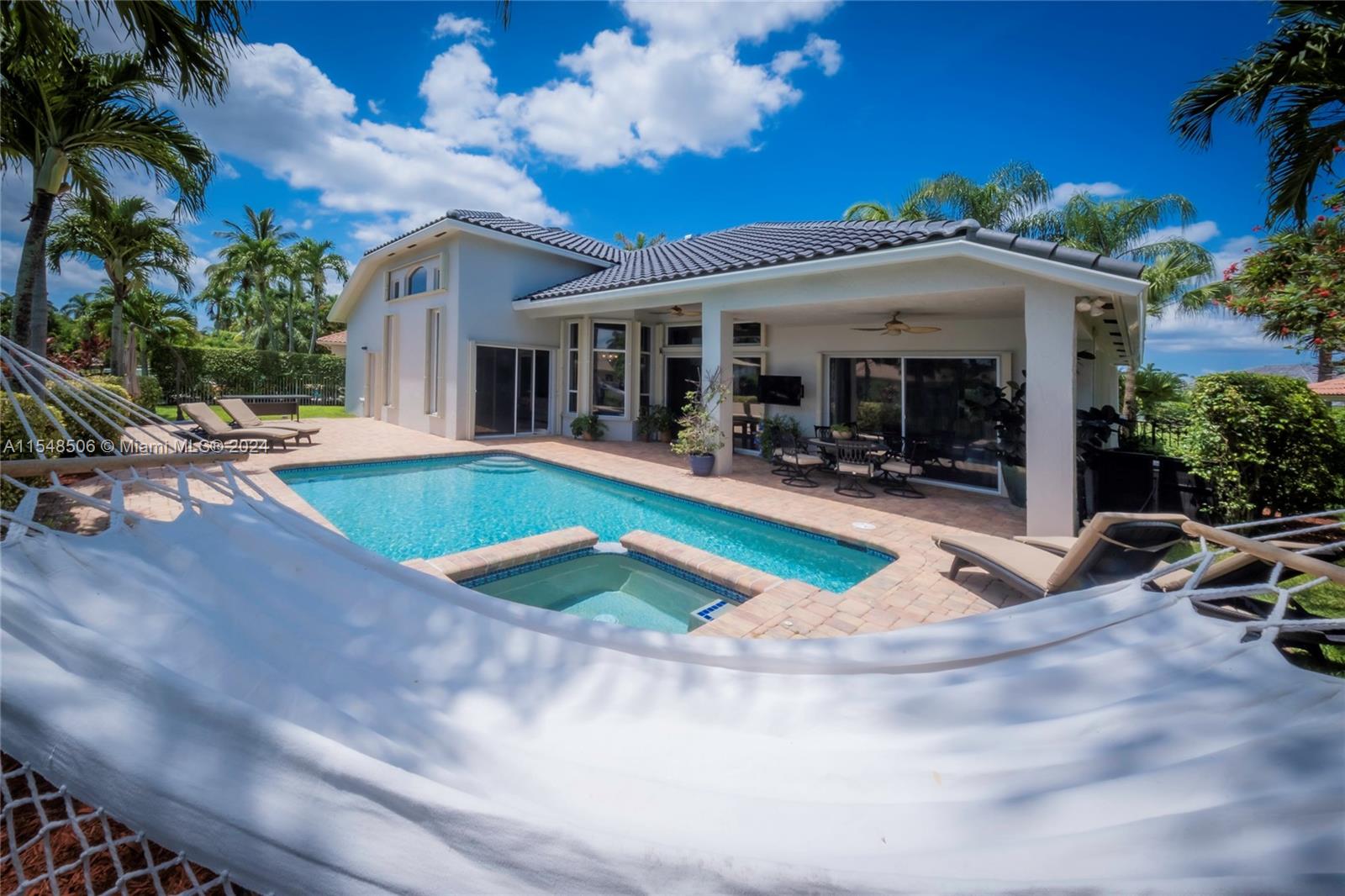 10849-10849 Bal Harbor Drive Boca Raton, FL 33498 - Photo 33 of 72 a view of a white house with swimming pool and sitting area