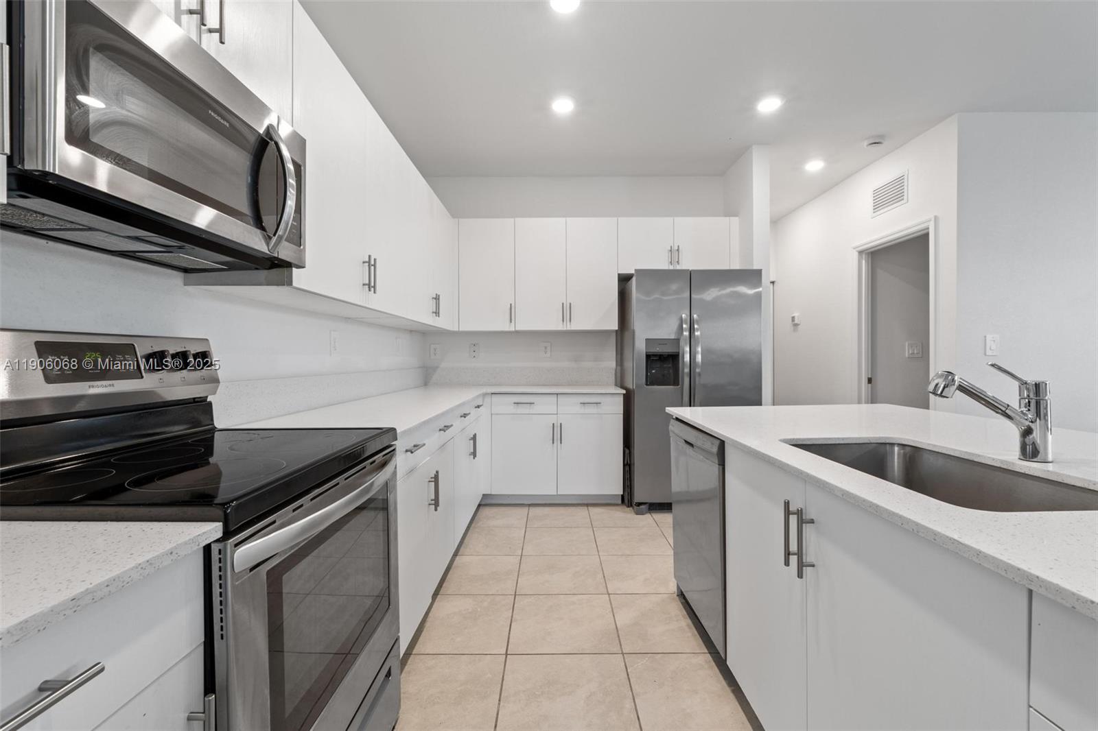 11903 Southwest 241st Street Homestead, FL 33032 - Photo 11 of 56 a kitchen with stainless steel appliances granite countertop a sink stove and refrigerator