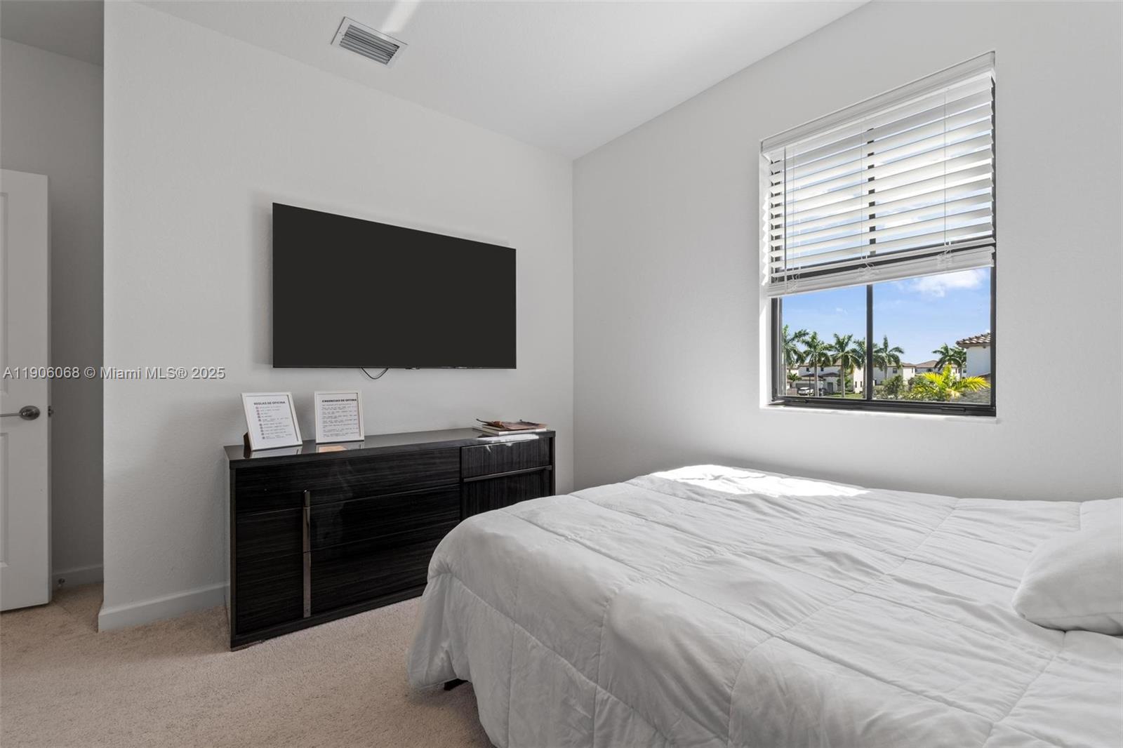 11903 Southwest 241st Street Homestead, FL 33032 - Photo 40 of 56 a bedroom with a bed and a flat screen tv