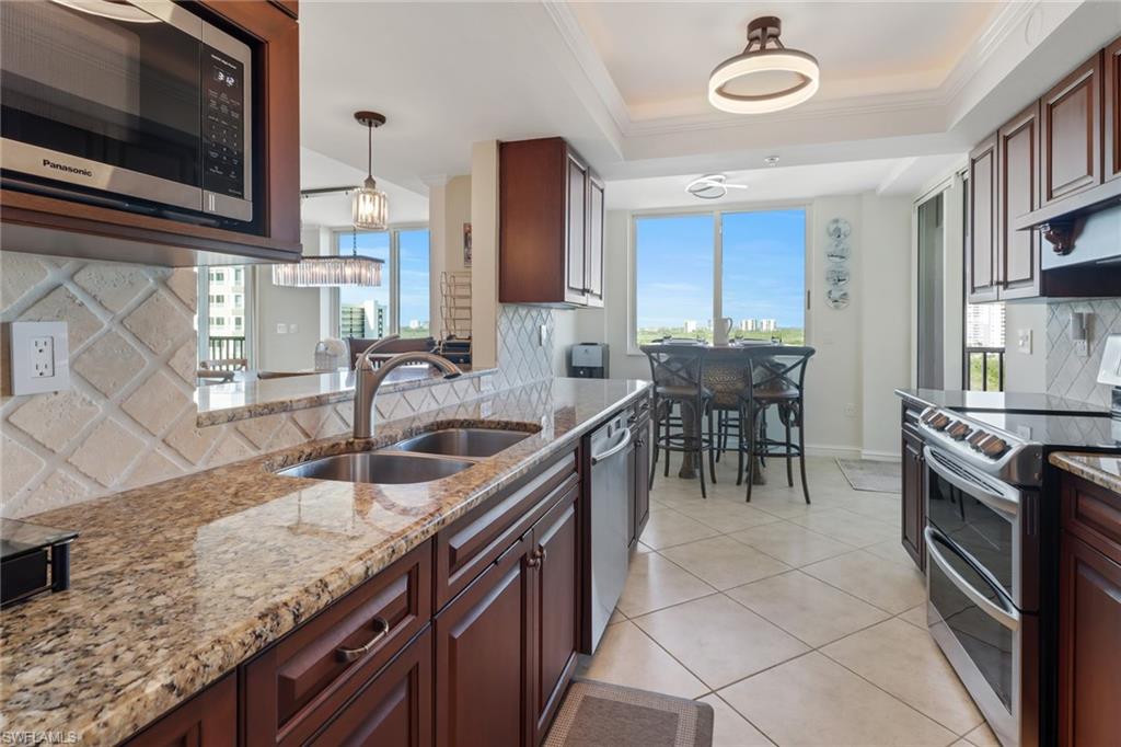 25 Bluebill Avenue, Unit A906 Naples, FL 34108 - Photo 15 of 40 a kitchen with stainless steel appliances granite countertop a sink and a stove