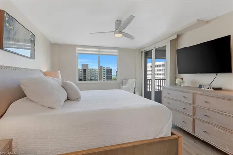 a bedroom with a bed tv and a chandelier