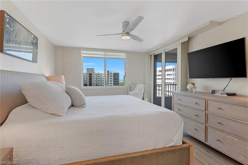 25 Bluebill Avenue, Unit A906 Naples, FL 34108 - Photo 19 of 40 a bedroom with a large bed and a flat screen tv