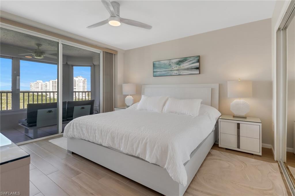 25 Bluebill Avenue, Unit A906 Naples, FL 34108 - Photo 28 of 40 a bedroom with a large bed and a chandelier