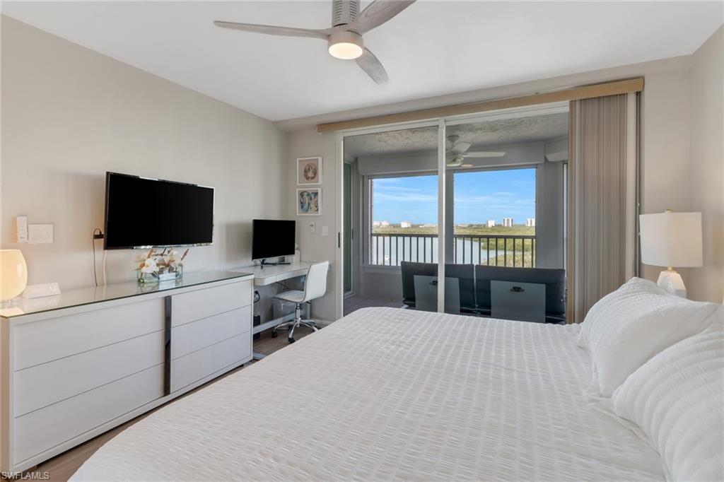 25 Bluebill Avenue, Unit A906 Naples, FL 34108 - Photo 29 of 40 a bedroom with a large bed and a flat screen tv
