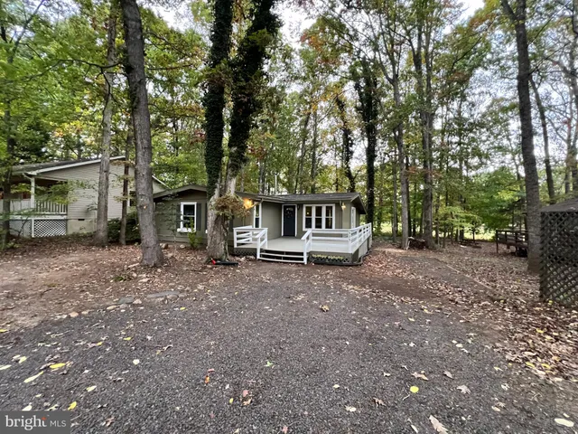 a view of a house with backyard and a trees