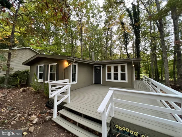 a front view of house with deck and yard