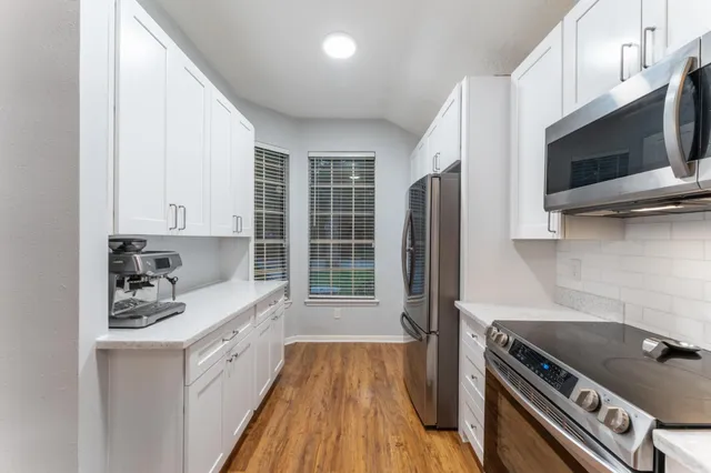a kitchen with stainless steel appliances a stove a sink and a microwave